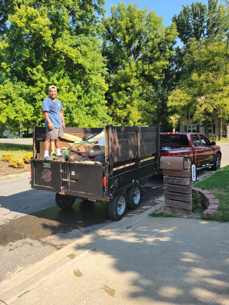 BoroBoys crew member with a loaded dump trailer after a residential junk removal job