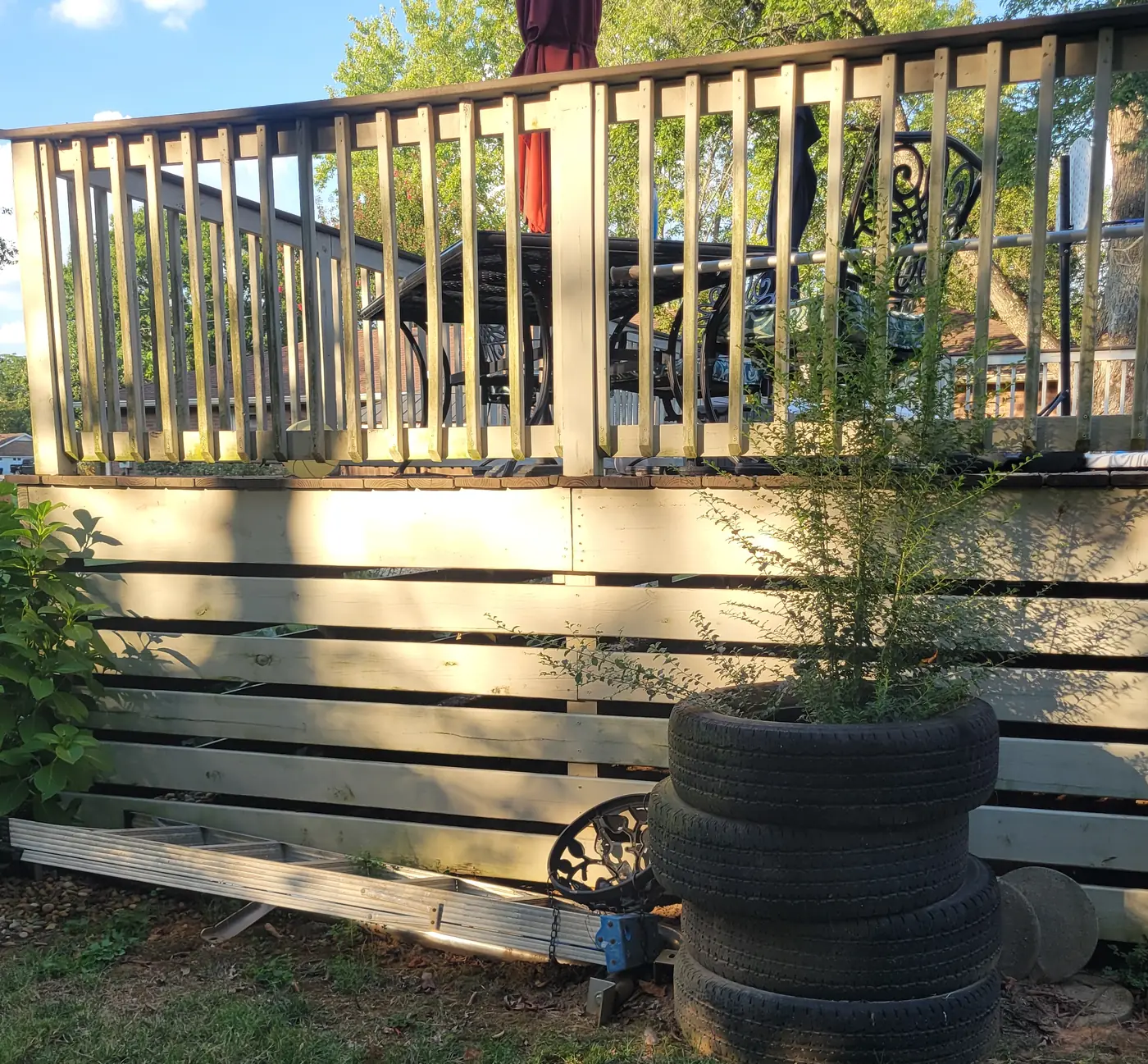 Before: old tires, a ladder and debris piled along a backyard deck
