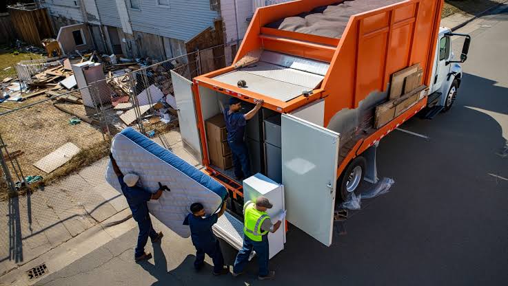 Junk removal team loading a mattress and large items into a box truck in Murfreesboro TN
