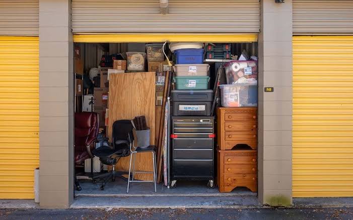 Storage unit filled with office furniture toolboxes and clutter for commercial junk removal in Murfreesboro TN